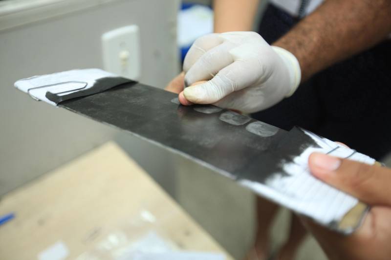 Uma média de 50 a 60 mil RGs foram emitidos (foto) por mês em todo o Pará pela Diretoria de Identificação "Enéas Martins" (Didem), da Polícia Civil, de janeiro a novembro de 2018. O número é considerado alto e é resultado da maior agilidade no atendimento para a emissão e entrega do documento, possível após a possibilidade de agendamento pelo site do órgão de segurança pública. Antes, longas filas se formavam na frente da Delegacia Geral do Estado, o principal posto de atendimento. A diretora da Didem, Juliete Monteiro, conta que com a modernização da polícia no interior do Estado contribuiu com o aumento das emissões e com a diminuição do prazo para a entrega do documento. “Tinha município que esperava até 40 dias. Com a informatização, o prazo diminuiu bastante”, diz. Além disso, Juliete lembra que o agendamento informatizado inibiu situações irregulares, como a venda de senha para o atendimento. Atualmente, 44 municípios do Estado são informatizados. Destes, 32 passaram pela modernização de sistema nos últimos oito anos de gestão do governador Simão Jatene. “Agora temos muito mais possibilidades no interior. Quem não tem posto de atendimento no seu município, pode fazer na cidade mais próxima. Temos muito ainda pela frente, mas estamos caminhando para que o usuário aguarde cada vez menos tempo para receber seu RG”, concluiu.

FOTO: MÁCIO FERREIRA / AG. PARÁ
DATA: 03.12.2018
BELÉM - PARÁ
 <div class='credito_fotos'>Foto: MÁCIO FERREIRA/ AG. PARÁ   |   <a href='/midias/2018/originais/06b3cf58-2006-47d6-ab7b-075519bb4173.jpg' download><i class='fa-solid fa-download'></i> Download</a></div>