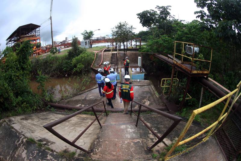 A Secretaria de Estado de Meio Ambiente e Sustentabilidade (Semas) notificou oficialmente a Hydro, na tarde desta terça-feira (27), por conta do não cumprimento do prazo de 48 horas dado pelo governo para que a empresa reduzisse os níveis das bacias de resíduos ao nível de, pelo menos, um metro, conforme determina a legislação ambiental. A notificação foi entregue por técnicos da Semas na sede da refinaria, em Barcarena, a 112 quilômetros de Belém. A determinação é que a produção de alumina seja reduzida pela metade. A Semas também triplicará a multa definida anteriormente, cumprindo a legislação ambiental em vigor, para R$ 1 milhão por dia de descumprimento (ou 300 mil Unidades de Padrão Fiscal). A empresa informou formalmente que reduziu os índices, mas não integralmente no total determinado de um metro. Técnicos das diretorias de Fiscalização e Licenciamento Ambiental da Semas acompanham diariamente o volume de água das bacias, tanto dos depósitos de rejeitos sólidos da indústria quanto do sistema de tratamento de água.
FOTO: THIAGO GOMES / AG PARÁ
DATA: 27.02.2018
BARCARENA - PARÁ <div class='credito_fotos'>Foto: Thiago Gomes /Ag. Pará | <a href='/midias/2018/originais/0877e358-5a19-4ff8-9fd5-f1208e10a503.jpg' download><i class='fa-solid fa-download'></i> Download</a></div>