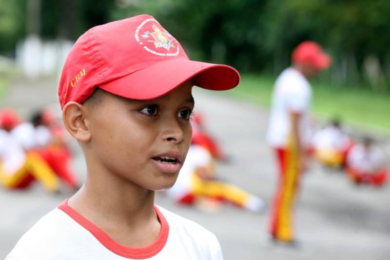 EO Corpo de Bombeiros Militar do Pará também atua com um projeto de responsabilidade social que oferece perspectivas às crianças e adolescentes. O “Escola da Vida” começou no quartel da Cremação em 1993, com apenas 20 alunos. Hoje, alcança 3.200 alunos matriculados e distribuídos em 25 polos pelo Estado. Mais de 25 mil crianças já passaram pelo projeto que oferece informações, orientações, treinamento, educação e base de apoio para a formação do cidadão. Dos 25 polos do Projeto Escola da Vida, cinco estão em Belém, nos bairros da Cremação e Val de Cans, além de Icoaraci, Outeiro e Mosqueiro, funcionando dentro dos quartéis. Na foto, Éric Macedo, 13 anos.
FOTO: SIDNEY OLIVEIRA / AG. PARÁ
DATA: 11.05.2018
BELÉM - PARÁ <div class='credito_fotos'>Foto: Sidney Oliveira/Ag. Pará | <a href='/midias/2018/originais/08dc295f-1291-4b59-87d8-7782912d40f4.jpg' download><i class='fa-solid fa-download'></i> Download</a></div>