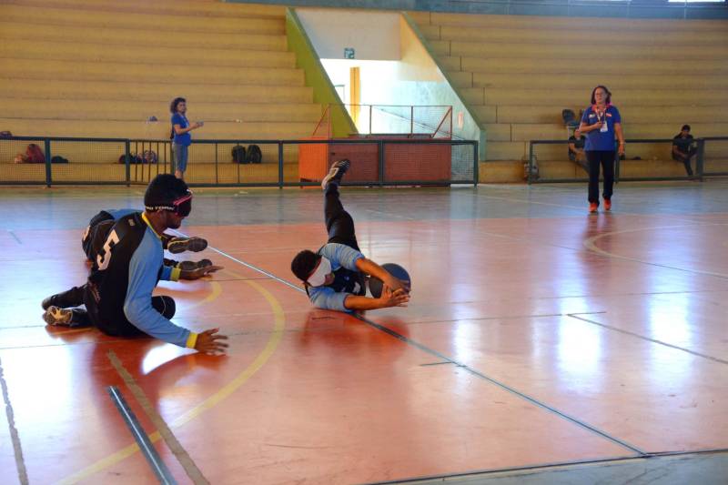 A Secretaria de Estado de Educação (Seduc), por meio do Núcleo de Esporte e Lazer (NEL), promove oficinas de capacitação destinada a professores e técnicos das escolas dos municípios participantes da XI edição dos Jogos Paralímpicos Escolares Paraenses, visando destacar a importância do incentivo à prática de esportes por pessoas com deficiência (PcD). As oficinas ocorrem paralelamente à competição, que será encerrada nesta sexta-feira (29), em Marabá, no sudeste do Estado, com disputas nas modalidades atletismo, bocha e natação. No Ginásio Renato Veloso ocorreu a oficina de goaball (foto), único esporte criado exclusivamente para deficientes visuais. A modalidade esportiva, que foi implantada de forma pioneira no Estado para ser praticado por estudantes da Unidade de Ensino Especializada Álvares de Azevedo, está sendo levada a outros municípios paraenses.
FOTO: FERNANDO NOBRE / ASCOM SEDUC
DATA: 29.06.2018
MARABÁ - PARÁ <div class='credito_fotos'>Foto: FERNANDO NOBRE/ASCOM SEDUC | <a href='/midias/2018/originais/0b2082a9-79a0-4dd1-9bd4-8eae3451e438.jpg' download><i class='fa-solid fa-download'></i> Download</a></div>