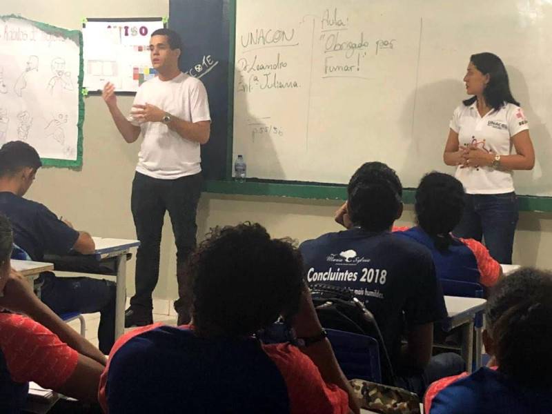 Cerca de 250 estudantes de escolas públicas do ensino fundamental e médio foram alvo da ação de educação em saúde promovida pela Unidade de Alta Complexidade em Oncologia Dr Vitor Moutinho (Unacon), em Tucuruí, com o objetivo de combater o tabagismo que é responsável por cerca de 30% das mortes pelos mais diversos tipos de câncer, entre eles, de pulmão,  laringe, faringe, esôfago, estômago, pâncreas, fígado, rim, bexiga, colo do útero e leucemias. A ação realizada pelo Grupo de Trabalho de Humanização (GTH) da unidade, que é referência no tratamento de câncer no sudeste paraense, levou especialistas às escolas para alertar sobre os perigos do tabagismo que atualmente é o maior fator de risco evitável de adoecimento e morte no mundo e, cada vez mais, envolve crianças e adolescentes. Na foto, o médico oncologista da Unacon, Leandro Almeida (camisa branca) durante as ações nas escolas de Tucuruí.

FOTO: ASCOM / UNACON
DATA: 19.05.2018
TUCURUÍ - PARÁ <div class='credito_fotos'>Foto: Ascom Unacon   |   <a href='/midias/2018/originais/348cb41c-b71e-42d5-a993-657962a84d7c.jpg' download><i class='fa-solid fa-download'></i> Download</a></div>