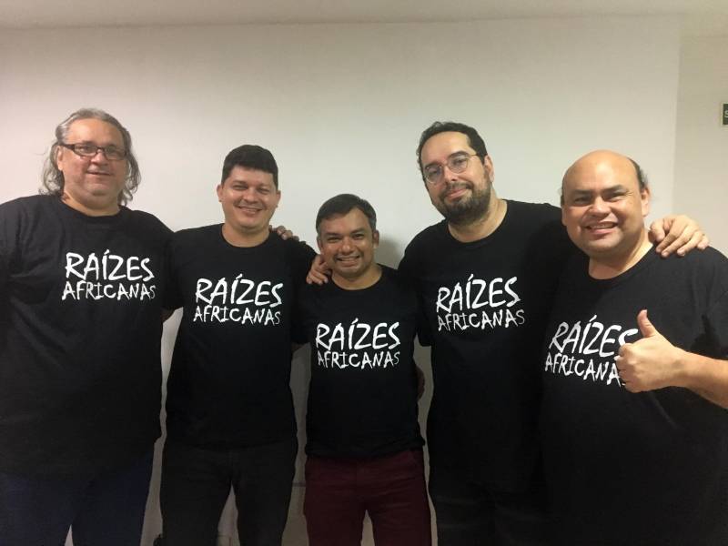Neste domingo (20), um grupo de cinco professores da rede pública e particular de ensino vão estar reunidos no auditório Ismael Nery, da Fundação Cultural do Estado do Pará, das 7h30 às 13h00, para um ciclo de cinco palestras e debates sobre “Escravidão, Resistência e Raízes Africanas no Brasil”. A equipe de professores reuniu-se para estudos interdisciplinares, a fim de alcançar outros professores e estudantes, e os induzir à reflexão crítica sobre o tema. A iniciativa partiu do historiador Júlio Charchar, autor do livro Memórias da Escravidão Negra no Brasil, que será distribuído gratuitamente a todos os participantes do evento. O evento contará também com a presença do professor Márcio Marçal, que vai abordar as formas de resistência dos escravos no campo e na cidade, utilizando documentos históricos do século XIX, que destacam os abolicionismos e o protagonismo do negro no contexto escravocrata, além de tratar do período pós-abolição e da dinâmica que norteia a exclusão étnico-racial na contemporaneidade. Na foto (da esq/dir), Márcio Marçal, Aldemir Vasconcelos, Júlio Charchar, Raimundo Marques e Helder Bentes.
FOTO: ASCOM / FCP
DATA: 20.05.2018
BELÉM - PARÁ <div class='credito_fotos'>Foto: ASCOM FCP | <a href='/midias/2018/originais/361550f2-9c32-4b70-b730-6b8851792c90.jpg' download><i class='fa-solid fa-download'></i> Download</a></div>