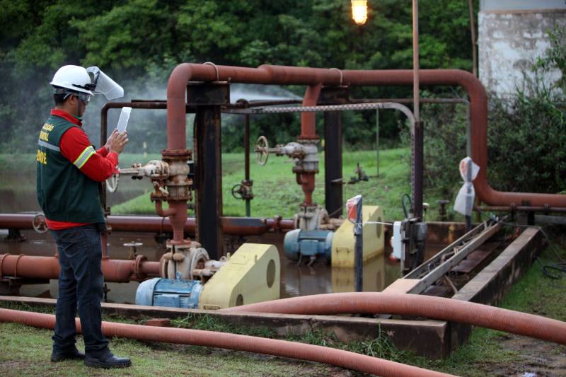 A Secretaria de Estado de Meio Ambiente e Sustentabilidade (Semas) notificou oficialmente a Hydro, na tarde desta terça-feira (27), por conta do não cumprimento do prazo de 48 horas dado pelo governo para que a empresa reduzisse os níveis das bacias de resíduos ao nível de, pelo menos, um metro, conforme determina a legislação ambiental. A notificação foi entregue por técnicos da Semas na sede da refinaria, em Barcarena, a 112 quilômetros de Belém. A determinação é que a produção de alumina seja reduzida pela metade. A Semas também triplicará a multa definida anteriormente, cumprindo a legislação ambiental em vigor, para R$ 1 milhão por dia de descumprimento (ou 300 mil Unidades de Padrão Fiscal). A empresa informou formalmente que reduziu os índices, mas não integralmente no total determinado de um metro. Técnicos das diretorias de Fiscalização e Licenciamento Ambiental da Semas acompanham diariamente o volume de água das bacias, tanto dos depósitos de rejeitos sólidos da indústria quanto do sistema de tratamento de água.
FOTO: THIAGO GOMES / AG PARÁ
DATA: 27.02.2018
BARCARENA - PARÁ <div class='credito_fotos'>Foto: Thiago Gomes /Ag. Pará | <a href='/midias/2018/originais/368c6a5b-c960-4a13-b80e-4bab2c367010.jpg' download><i class='fa-solid fa-download'></i> Download</a></div>