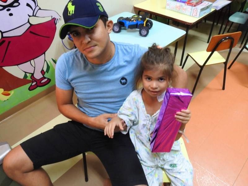 “Ela é muito bonita”. Assim a pequena Evelin Victhória Brigel Sousa, 4 anos, definiu a nova boneca que ganhou, na tarde desta quinta-feira (29), no Hospital Regional Público da Transamazônica (HRPT), em Altamira, no sudoeste do Pará. A menina se recupera na clínica pediátrica da unidade e foi uma das crianças presenteadas pelos “brinquedos de Páscoa”, em uma ação do Grupo de Trabalho de Humanização. A direção reuniu brinquedos doados pelos próprios colaboradores e entregou às crianças internadas no hospital, na clínica e na UTI pediátricas. Os usuários que puderam ainda assistiram a uma sessão de cinema na brinquedoteca, acompanhados dos pais, que aprovaram a iniciativa. Na foto, Efrain Lima Sousa, pai da Evelin.
FOTO: ASCOM / HRPT
DATA: 29.03.2018
ALTAMIRA - PARÁ <div class='credito_fotos'>Foto: ASCOM HRPT | <a href='/midias/2018/originais/3a45e6b4-919d-4405-b26b-b84f12b899d7.jpg' download><i class='fa-solid fa-download'></i> Download</a></div>