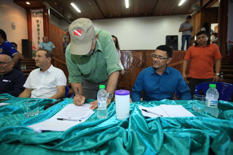 O produtor rural Nilson Corrêa da Silva, 23 anos, mora na comunidade Santo Ezequiel Moreno e produz alimentos em 700 hectares de terra na agrovila Acutipereira, no município de Portel, no arquipélago do Marajó. Mesmo morando e produzindo alimentos na comunidade, ele não possuía título de propriedade de terra. Para beneficiar produtores como Nilson, o governador Simão Jatene entregou, na manhã desta sexta-feira (23), títulos coletivos que beneficiaram mais de mil famílias. Os títulos também beneficiaram comunidades remanescentes de quilombos e povos tradicionais do município marajoara. O Pará foi o Estado que mais titulou áreas em prol dos remanescentes de quilombos no Brasil. Das 170 comunidades tituladas no país, 62 estão no Pará, sendo que destas 53 foram tituladas pelo Instituto de Terras do Pará (Iterpa). Na foto, assinatura do termo para pavimentação de 5 km de vias no município.

FOTO: MÁCIO FERREIRA / AG. PARÁ
DATA: 23.03.2018
PORTEL - PARÁ <div class='credito_fotos'>Foto: MÁCIO FERREIRA/ AG. PARÁ   |   <a href='/midias/2018/originais/3d929457-4ab9-4f65-8984-5dfab76b872a.jpg' download><i class='fa-solid fa-download'></i> Download</a></div>