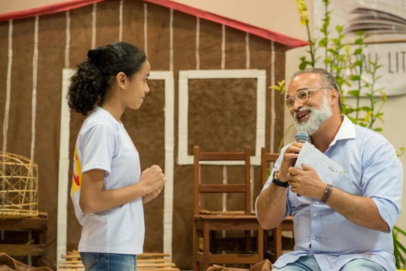 “A cultura tem o poder de emocionar”. A frase dita pela professora Ruth Valin marcou o tom do Sarau Literário na manhã desta sexta-feira, 8, no Preventório Santa Terezinha, no bairro do Marco, em Belém, que contou com a presença do escritor paraense Daniel Leite (com barba), homenageado pelas crianças atendidas pela instituição e os alunos da Escola Estadual Santa Terezinha, que funciona no mesmo prédio. Elas cantaram músicas infantis e recitaram trechos das obras “A história das crianças que plantaram um rio” e “A menina árvore”, de Daniel Leite, além de apresentar uma dramatização sobre a primeira obra. Muito concentrados e com a leitura bem ensaiada, os pequeninos emocionaram a todos, principalmente o escritor convidado para o sarau. Segundo a professora Odinéia Bastos, que orientou os alunos na leitura do livro “A história das crianças que plantaram um rio”, elas soltaram a imaginação durante a leitura da obra, e dessa viagem saíram desenhos, pinturas, colagens e poemas, que enfeitaram o auditório e os corredores da instituição, encantando a todos os presentes.
FOTO: FERNANDO SETTE CÂMARA / ASCOM IOE
DATA: 08.06.2018
BELÉM - PARÁ <div class='credito_fotos'>Foto: FERNANDO SETTE CÂMARA / ASCOM IOE | <a href='/midias/2018/originais/4c35aee4-f347-42e7-99b4-db0aab6bf6ac.jpg' download><i class='fa-solid fa-download'></i> Download</a></div>