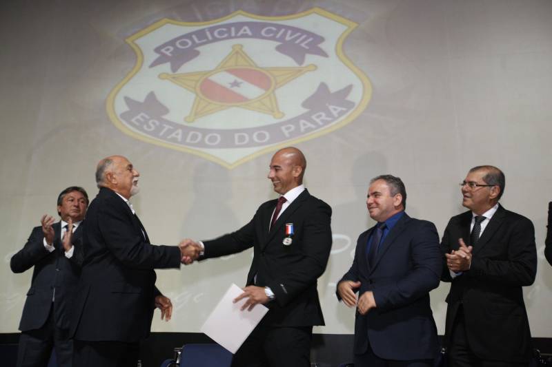 O Pará vai voltar a ter um delegado de polícia para cada município. A posse de 149 novos delegados da Polícia Civil, que aconteceu nesta segunda-feira (26) no Teatro Maria Sylvia Nunes, na Estação das Docas, vai garantir, com sobras, a cobertura completa dos 144 municípios do estado. Aprovados em concurso público, os novos delegados concluíram o curso de Formação da Polícia Civil do Pará no dia 15 deste mês. O curso foi o primeiro do Brasil a incluir sete disciplinas inéditas: Oratória, Atuação Policial frente aos Grupos Vulneráveis, Relacionamento com a Imprensa e Mídias Sociais, Abordagem Psicopatológica do Crime e da Violência, Investigação Financeira no Enfrentamento ao Crime de Lavagem de dinheiro, Noções Básicas de Enfrentamento às Fraudes Veiculares e Linguagem Brasileira de Sinais. O concurso aprovou ainda 300 investigadores, 180 escrivães e 20 papiloscopistas. Os novos policiais civis passaram por quatro meses de formação técnica e profissional na Acadepol. Com a nomeação, o próximo passo será a lotação dos novos servidores públicos nas unidades de Polícia Civil do estado, quando eles saberão em qual região do Pará trabalharão inicialmente. Na foto, o formando João Costa (calvo), primeiro lugar no curso.
FOTO: SYDNEY OLIVEIRA / AG. PARÁ
DATA: 26.02.2018
BELÉM - PARÁ <div class='credito_fotos'>Foto: Sidney Oliveira/Ag. Pará | <a href='/midias/2018/originais/52a65f85-67a7-4bc1-b66a-868bf55a9a6b.jpg' download><i class='fa-solid fa-download'></i> Download</a></div>
