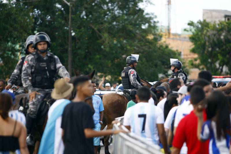 Foram exatos dois meses tentando assistir ao seu primeiro Re x Pa em 2018. Neste domingo, finalmente, a estudante Hendrea Souza convenceu o noivo, Arthur Pantoja, a levá-la ao Estádio Olímpico do Pará, o Mangueirão. E logo numa final. "Só trouxe porque vim no domingo passado e vi algumas mudanças no esquema de segurança", disse Arthur. "Tem mais policiais e a bebedeira em volta do estádio praticamente acabou", afirmou. As mudanças realmente aconteceram a partir do clássico do último dia primeiro e já surtiram efeito. A chamada “Operação Mangueirão” pôs em prática ações de ordenamento no entorno do estádio, com início a partir das 7h30 e encerramento às 20h. A operação determina a delimitação de espaço para atuação de vendedores ambulantes, proibição de veículos com sons automotivos ao redor do estádio e de barracas irregulares, seis pontos de bloqueio e dois para o ingresso de comerciantes e orientações ao público.
FOTO: THIAGO GOMES / AG. PARÁ
DATA: 08.04.2018
BELÉM - PARÁ <div class='credito_fotos'>Foto: Thiago Gomes /Ag. Pará | <a href='/midias/2018/originais/54fbc080-9e11-4ab9-b938-0bbfc4140fd0.jpg' download><i class='fa-solid fa-download'></i> Download</a></div>