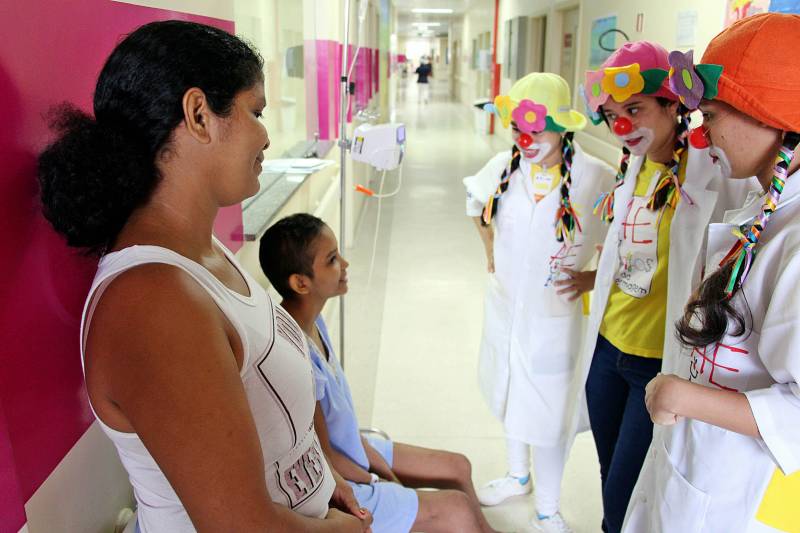As voluntárias atuam no suporte aos pacientes acolhidos pelo Hospital Oncológico Infantil Octávio Lobo, em Belém (PA). Observadora como Maria Domingas, Midene Batista percebeu algo errado com a filha de seis anos e procurou ajuda. “Fui dar um banho nela e percebi algo diferente na região do abdômen. Tive medo, porque é minha única filha, mas hoje ela é primeira a me dizer que está tudo bem”, contou a mãe, que saiu do município do Acará, no nordeste paraense, e há três anos acompanha a filha em tratamento contra o tumor de Wilms, um tipo de câncer renal que acomete frequentemente crianças. As filhas de Maria Domingas (E) e Midene Batista ainda são jovens e têm histórias parecidas que envolvem o câncer. A doença que, segundo estimativas do Instituto Nacional do Câncer (Inca), deve ter 600 mil novos casos no Brasil somente em 2018. Desta projeção, cerca de 23 mil casos deverão ser diagnosticados na região Norte, onde o Pará é referência no diagnóstico e tratamento de câncer infantojuvenil e adulto com atuação no Hospital Oncológico Infantil Octávio Lobo, em Belém, e o Hospital Regional do Baixo Amazonas (HRBA), em Santarém.
FOTO: ASCOM / HOIOL
DATA: 06.04.2018
BELÉM - PARÁ <div class='credito_fotos'>Foto: ASCOM HOIOL | <a href='/midias/2018/originais/551e8e26-f347-4ac7-906e-bf55e42348e0.jpg' download><i class='fa-solid fa-download'></i> Download</a></div>