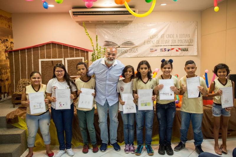 “A cultura tem o poder de emocionar”. A frase dita pela professora Ruth Valin marcou o tom do Sarau Literário na manhã desta sexta-feira, 8, no Preventório Santa Terezinha, no bairro do Marco, em Belém, que contou com a presença do escritor paraense Daniel Leite (com barba), homenageado pelas crianças atendidas pela instituição e os alunos da Escola Estadual Santa Terezinha, que funciona no mesmo prédio. Elas cantaram músicas infantis e recitaram trechos das obras “A história das crianças que plantaram um rio” e “A menina árvore”, de Daniel Leite, além de apresentar uma dramatização sobre a primeira obra. Muito concentrados e com a leitura bem ensaiada, os pequeninos emocionaram a todos, principalmente o escritor convidado para o sarau. Segundo a professora Odinéia Bastos, que orientou os alunos na leitura do livro “A história das crianças que plantaram um rio”, elas soltaram a imaginação durante a leitura da obra, e dessa viagem saíram desenhos, pinturas, colagens e poemas, que enfeitaram o auditório e os corredores da instituição, encantando a todos os presentes.
FOTO: FERNANDO SETTE CÂMARA / ASCOM IOE
DATA: 08.06.2018
BELÉM - PARÁ <div class='credito_fotos'>Foto: FERNANDO SETTE CÂMARA / ASCOM IOE | <a href='/midias/2018/originais/57e9b935-69fa-46af-8eff-1da3f221c65d.jpg' download><i class='fa-solid fa-download'></i> Download</a></div>