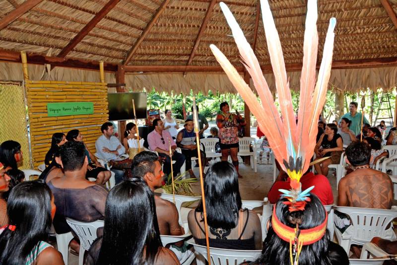O que motiva um grupo de jovens indígenas da nação indígena Gavião, a concluir o Ensino Médio sem sair da aldeia, localizada no município Bom Jesus do Tocantins, na região sudeste do Estado? A escola construída dentro da reserva, em forma de maloca, com toda natureza ao redor, foi determinante para manter o foco dos alunos do Mundiar nos estudos. Mas a professora, algumas vezes, preferiu levar a aula para o meio da plantação ou para a beira do rio. Uma atitude pedagógica com elevado significado. A estratégia de relacionar o conteúdo da proposta na Matriz Curricular à realidade da aldeia Akrãkikatêjê, durante as aulas, foi montada pela cacique Kátia Tonkyre, para cumprir a promessa feita em 2016, quando a turma foi formada, de que todos os estudantes matriculados iriam se empenhar ao máximo para concluir o Ensino Médio, por meio da metodologia do Projeto Mundiar (foto), implantado pela Secretaria de Estado de Educação (Seduc). O Mundiar visa corrigir a distorção escolar idade/ano e reduzir a repetência e a evasão de alunos.
FOTO: FERNANDO NOBRE / ASCOM SEDUC
DATA: 15.06.2018
BOM JESUS DO TOCANTINS - PARÁ <div class='credito_fotos'>Foto: FERNANDO NOBRE/ASCOM SEDUC | <a href='/midias/2018/originais/5e72d1a4-7aea-4a48-8e49-e1650ae4d6fb.jpg' download><i class='fa-solid fa-download'></i> Download</a></div>