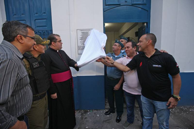Leia Braúna mora há dois anos e meio no bairro da Cidade Velha e vê com alegria a instalação de uma sede da Polícia Militar na Rua Dr. Assis, bem pertinho de sua casa. O novo prédio da 1ª Companhia do 2º Batalhão da PM foi inaugurado na tarde desta quinta-feira, 5, e agora além de estar mais acessível aos moradores dos bairros da Campina, Reduto e Cidade Velha, oferece melhores condições de trabalho aos militares. O local foi cedido pela Arquidiocese de Belém em fevereiro deste ano de forma gratuita e por tempo indeterminado. Antes disso, a sub-unidade funcionava no 3º andar da seccional do Comércio. O Major Luiz Octávio, comandante do 2º Batalhão, informa que a Companhia atua com 165 policiais militares, que atendem cerca de 24 mil moradores da área. “A proximidade da Polícia Militar com a comunidade é um ponto primordial da instalação da 1ª Companhia, além de ser estratégico, porque se coloca em uma posição de atendimento rápido tanto ao Reduto, quanto para Campina e a própria Cidade Velha”, afirmou o oficial.
FOTO: CARLOS SODRÉ / AG. PARÁ
DATA: 05.04.2018
BELÉM - PARÁ <div class='credito_fotos'>Foto: Carlos Sodré/Agência Pará | <a href='/midias/2018/originais/60d799a5-bfe5-41ec-b025-4e637e203954.jpg' download><i class='fa-solid fa-download'></i> Download</a></div>
