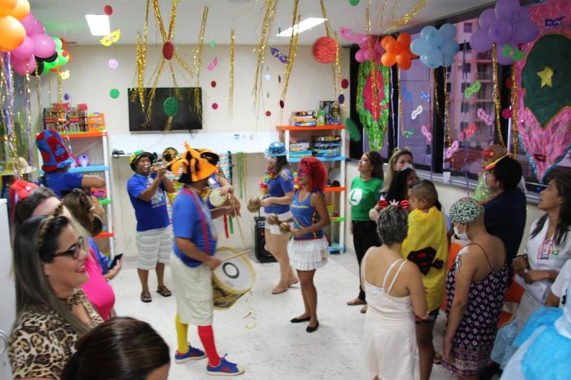 Quando os primeiros chapéus coloridos começaram a surgir e o som dos tambores passou a ecoar pelos corredores do Hospital Oncológico Infantil Octávio Lobo, portas dos quartos começaram a se abrir revelando rostos curiosos para ver que movimento diferente era aquele. Toda aquela animação vinha do Arraial do Pavulagem que, assim como faz em seus cortejos pelas ruas de Belém, literalmente arrastou as crianças e adolescentes em tratamento no Oncológico Infantil, para o tradicional Baile de Carnaval da unidade, que é gerenciada pela Pró-Saúde Associação Beneficente de Assistência Social e Hospitalar, sob contrato de gestão com a Secretaria de Estado de Saúde Pública (Sespa).
FOTO: ASCOM / HOIOL
DATA: 10.02.2018
BELÉM - PARÁ <div class='credito_fotos'>Foto: ASCOM HOIOL | <a href='/midias/2018/originais/65ac68e4-e8c5-4a59-8326-1e4df2622cb1.jpg' download><i class='fa-solid fa-download'></i> Download</a></div>