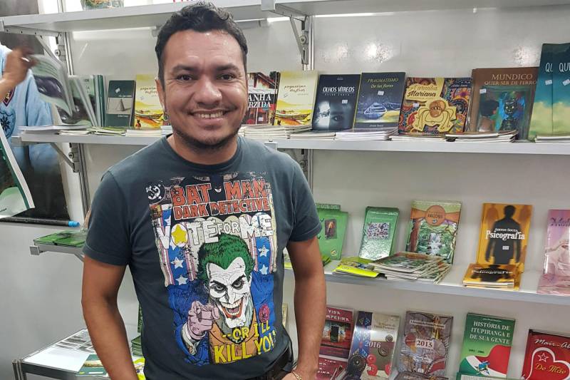 Lado a lado estão os estandes da Academia de Letras de Marabá (Alma) e a Academia de Letras do Sul e Sudeste do Estado, que reúnem juntos mais de 80 publicações de escritores da região. Membro de ambas, Airton Souza (foto), autor marabaense com 31 livros publicados, afirma que a literatura regional tem se fortalecido.
FOTO: ASCOM CRGSP
DATA: 02.05.2018
MARABÁ - PARÁ <div class='credito_fotos'>Foto: ASCOM CRGSP | <a href='/midias/2018/originais/75cbfe16-2e18-4299-8b74-26d650d17235.jpg' download><i class='fa-solid fa-download'></i> Download</a></div>