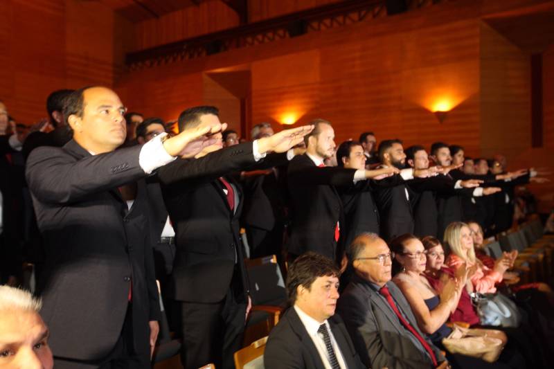O Pará vai voltar a ter um delegado de polícia para cada município. A posse de 149 novos delegados da Polícia Civil, que aconteceu nesta segunda-feira (26) no Teatro Maria Sylvia Nunes, na Estação das Docas, vai garantir, com sobras, a cobertura completa dos 144 municípios do estado. Aprovados em concurso público, os novos delegados concluíram o curso de Formação da Polícia Civil do Pará no dia 15 deste mês. O curso foi o primeiro do Brasil a incluir sete disciplinas inéditas: Oratória, Atuação Policial frente aos Grupos Vulneráveis, Relacionamento com a Imprensa e Mídias Sociais, Abordagem Psicopatológica do Crime e da Violência, Investigação Financeira no Enfrentamento ao Crime de Lavagem de dinheiro, Noções Básicas de Enfrentamento às Fraudes Veiculares e Linguagem Brasileira de Sinais. O concurso aprovou ainda 300 investigadores, 180 escrivães e 20 papiloscopistas. Os novos policiais civis passaram por quatro meses de formação técnica e profissional na Acadepol. Com a nomeação, o próximo passo será a lotação dos novos servidores públicos nas unidades de Polícia Civil do estado, quando eles saberão em qual região do Pará trabalharão inicialmente.
FOTO: SYDNEY OLIVEIRA / AG. PARÁ
DATA: 26.02.2018
BELÉM - PARÁ <div class='credito_fotos'>Foto: Sidney Oliveira/Ag. Pará | <a href='/midias/2018/originais/78b90b62-2846-427a-a844-c7617c01c68c.jpg' download><i class='fa-solid fa-download'></i> Download</a></div>