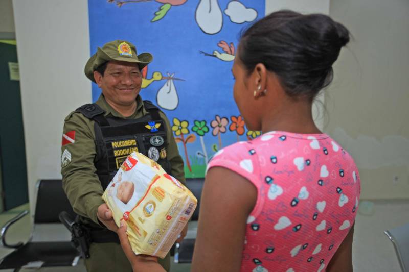 Aos 44 anos, Adailson Teixeira (e), sargento da Polícia Militar do Pará e atualmente lotado no Batalhão de Polícia Rodoviária, nunca imaginou que auxiliaria no parto de uma criança. Pai de três filhos, o militar nunca acompanhou o nascimento dos descendentes. Ele recorda que comentou a possibilidade com a esposa na última semana: “Já pensou se eu tivesse que fazer um parto desse? Não sei o que eu faria”. Só que na madrugada desta segunda-feira (14), o sargento foi o responsável por ajudar Marília Monteiro Barbosa (d), de 21 anos, a ter a filha Maria Eduarda. Marília vinha do Acará pela Alça Viária junto com a irmã quando iniciou o trabalho de parto. “Ela estava com dores e resolvemos vir para Belém. Quando chegou no KM 7 da Alça Viária a bolsa estourou e ficamos muito agoniadas. O motorista que trazia a gente parou na barreira da polícia e ele (o sargento) nos ajudou. Eu não conseguia fazer nada, nem o motorista. Se não fosse ele não sei o que ia acontecer”, contou a tia da criança, de 17 anos, que teve o nome preservado.
FOTO: MÁCIO FERREIRA / AG. PARÁ
DATA: 14.05.2018
BELÉM - PARÁ <div class='credito_fotos'>Foto: MÁCIO FERREIRA/ AG. PARÁ | <a href='/midias/2018/originais/78fa7ef2-11ab-4632-9dc2-d8a465018bba.jpg' download><i class='fa-solid fa-download'></i> Download</a></div>