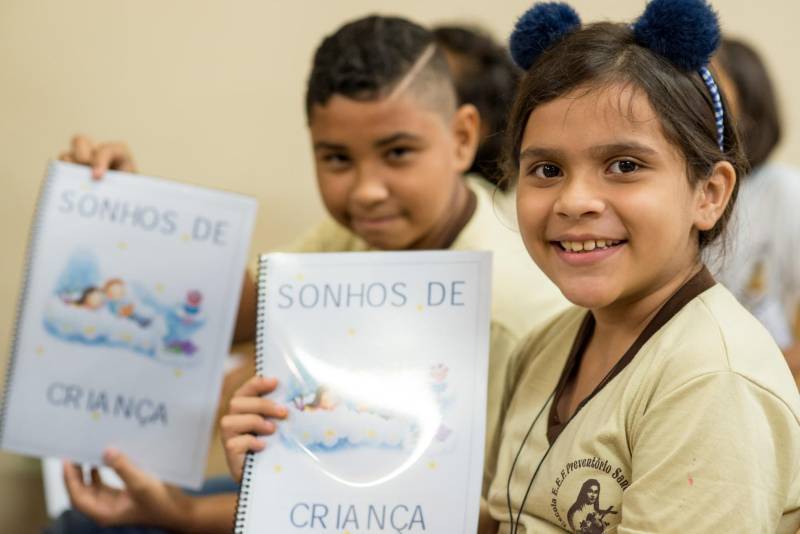 “A cultura tem o poder de emocionar”. A frase dita pela professora Ruth Valin marcou o tom do Sarau Literário na manhã desta sexta-feira, 8, no Preventório Santa Terezinha, no bairro do Marco, em Belém, que contou com a presença do escritor paraense Daniel Leite, homenageado pelas crianças atendidas pela instituição e os alunos da Escola Estadual Santa Terezinha, que funciona no mesmo prédio. Elas cantaram músicas infantis e recitaram trechos das obras “A história das crianças que plantaram um rio” e “A menina árvore”, de Daniel Leite, além de apresentar uma dramatização sobre a primeira obra. Muito concentrados e com a leitura bem ensaiada, os pequeninos emocionaram a todos, principalmente o escritor convidado para o sarau. Segundo a professora Odinéia Bastos, que orientou os alunos na leitura do livro “A história das crianças que plantaram um rio”, elas soltaram a imaginação durante a leitura da obra, e dessa viagem saíram desenhos, pinturas, colagens e poemas, que enfeitaram o auditório e os corredores da instituição, encantando a todos os presentes.
FOTO: FERNANDO SETTE CÂMARA / ASCOM IOE
DATA: 08.06.2018
BELÉM - PARÁ <div class='credito_fotos'>Foto: FERNANDO SETTE CÂMARA / ASCOM IOE | <a href='/midias/2018/originais/7ce66e2a-955f-4d2f-bd77-6ec8de1e13ee.jpg' download><i class='fa-solid fa-download'></i> Download</a></div>