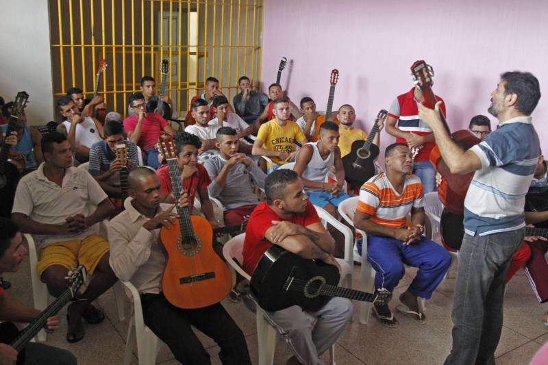 O detento Gerson Teixeira, de 31 anos, sempre se interessou pela música, mas fora do presídio nunca teve oportunidade de fazer um curso de violão. “Eu não tinha condições que comprar um violão e nem de pagar um curso, tenho família para sustentar e as minhas prioridades eram outras. Eu precisava pensar que primeiro tinha que colocar comida na mesa. Nem imaginava que aqui dentro do presídio eu ia realizar meu sonho, estou muito feliz e pretendo me dedicar às aulas”, disse o interno. Gerson é um dos 40 detentos que vão participar do projeto “Sala de Cordas” (foto), que iniciou hoje na Central de Triagem Metropolitana III (CTM III) que fica dentro do Complexo Penitenciário de Santa Izabel. O projeto foi uma iniciativa da coordenadora pedagógica da unidade prisional, Suely Carvalho, que juntamente com a Coordenadoria de Educação Prisional da Superintendência do Sistema Penitenciário do Estado (Susipe), foram em busca de uma parceria com a Fundação Cultural do Pará que doou 20 violões para que o curso pudesse ser ministrado dentro do presídio.
FOTO: AKIRA ONUMA / ASCOM SUSIPE
DATA: 04.04.2018
BELÉM - PARÁ <div class='credito_fotos'>Foto: Akira Onuma / Ascom Susipe | <a href='/midias/2018/originais/83ef0bb1-97a4-4269-91f9-c12e11acf550.jpg' download><i class='fa-solid fa-download'></i> Download</a></div>