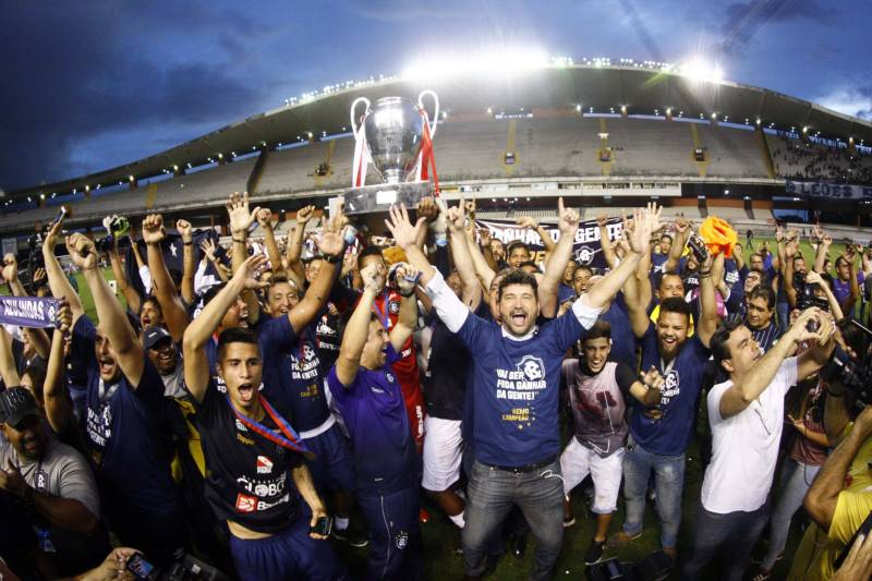 Foram exatos dois meses tentando assistir ao seu primeiro Re x Pa em 2018. Neste domingo, finalmente, a estudante Hendrea Souza convenceu o noivo, Arthur Pantoja, a levá-la ao Estádio Olímpico do Pará, o Mangueirão. E logo numa final. "Só trouxe porque vim no domingo passado e vi algumas mudanças no esquema de segurança", disse Arthur. "Tem mais policiais e a bebedeira em volta do estádio praticamente acabou", afirmou. As mudanças realmente aconteceram a partir do clássico do último dia primeiro e já surtiram efeito. A chamada “Operação Mangueirão” pôs em prática ações de ordenamento no entorno do estádio, com início a partir das 7h30 e encerramento às 20h. A operação determina a delimitação de espaço para atuação de vendedores ambulantes, proibição de veículos com sons automotivos ao redor do estádio e de barracas irregulares, seis pontos de bloqueio e dois para o ingresso de comerciantes e orientações ao público.
FOTO: THIAGO GOMES / AG. PARÁ
DATA: 08.04.2018
BELÉM - PARÁ <div class='credito_fotos'>Foto: Thiago Gomes /Ag. Pará | <a href='/midias/2018/originais/8a77ee37-dff8-4fc4-8416-50e2150d5f8e.jpg' download><i class='fa-solid fa-download'></i> Download</a></div>