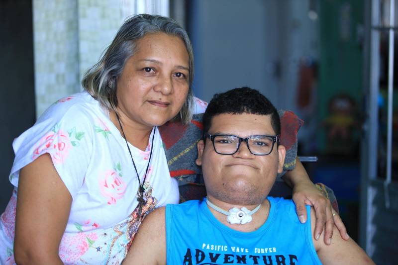 Junto com a Classe Hospitalar, existe também o projeto Atendimento Domiciliar que, hoje, atende 13 pacientes que se encontram em tratamento em casa. Um dos maiores orgulhos da equipe de educadores da Seduc é Breno Santiago, de 21 anos. Aos dois anos, Breno teve uma infecção na medula e chegou a ser desenganado pelos médicos, mas resistiu e mesmo com comprometimentos na parte física e na fala, teve sua capacidade cognitiva preservada. Ele aprendeu a ler e a escrever com uma equipe de oito professores do Atendimento Domiciliar, e hoje se prepara para fazer a segunda prova do Exame Nacional de Ensino Médio (Enem), que acontece no próximo domingo (11). Na foto, a mãe de Breno, a dona de casa Maria de Nazaré Santiago, 49 anos.
FOTO: MÁCIO FERREIRA / AG. PARÁ
DATA: 08.11.2018
BELÉM - PARÁ <div class='credito_fotos'>Foto: MÁCIO FERREIRA/ AG. PARÁ | <a href='/midias/2018/originais/8b32ed3b-439f-4637-9e39-62ff9bd1766a.jpg' download><i class='fa-solid fa-download'></i> Download</a></div>