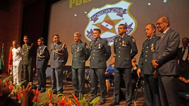 A Polícia Civil condecorou em solenidade (foto) no Teatro Maria Sylvia Nunes da Estação das Docas, em Belém, na noite desta quinta-feira (17), mais de 130 pessoas, entre policiais civis e militares, representantes das Forças Armadas, servidores do Estado e do Governo Federal, dirigentes de associações comunitárias e profissionais liberais. O evento contou com a presença do secretário de Segurança Pública e Defesa Social, Luiz Fernandes Rocha, representante do governador Simão Jatene, e foi presidida pelo delegado-geral Claudio Galeno. O chefe da Polícia Civil fez um retrospecto, dos avanços conquistados nos últimos anos, pela instituição policial. Entre eles, a renovação de um terço do quadro de policiais civis em todo Estado, com incremento de mais de mil novos policiais civis entre os anos de 2011 e 2018. "Foram 23 novos policiais em 2011; 386 em 2014 e em 2018 mais 623, totalizando 1.032 novos policiais civis", detalhou. Atualmente, a Polícia Civil conta com mais de 3,4 mil policiais civis nos 144 municípios paraenses. Graças ao protagonismo do governador Simão Jatene, a Polícia Civil realizou dois concursos públicos em menos de quatro anos, um feito histórico na instituição policial e inédito em todo Brasil. 

FOTO: ASCOM / POLÍCIA CIVIL
DATA: 18.05.2018
BELÉM - PARÁ <div class='credito_fotos'>Foto: Ascom / Polícia Civil   |   <a href='/midias/2018/originais/9153fbb3-2600-4180-bfcf-57b775d82086.jpg' download><i class='fa-solid fa-download'></i> Download</a></div>