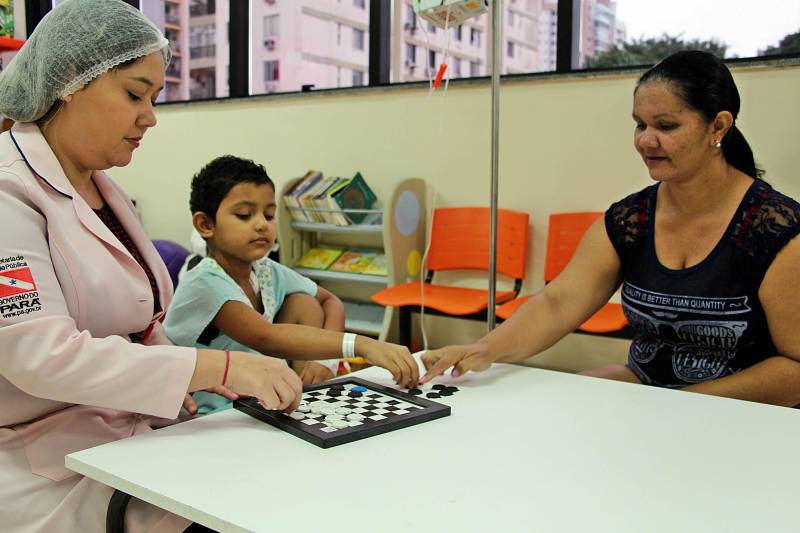 As voluntárias atuam no suporte aos pacientes acolhidos pelo Hospital Oncológico Infantil Octávio Lobo, em Belém (PA). Observadora como Maria Domingas, Midene Batista percebeu algo errado com a filha de seis anos e procurou ajuda. “Fui dar um banho nela e percebi algo diferente na região do abdômen. Tive medo, porque é minha única filha, mas hoje ela é primeira a me dizer que está tudo bem”, contou a mãe, que saiu do município do Acará, no nordeste paraense, e há três anos acompanha a filha em tratamento contra o tumor de Wilms, um tipo de câncer renal que acomete frequentemente crianças. As filhas de Maria Domingas e Midene Batista (D) ainda são jovens e têm histórias parecidas que envolvem o câncer. A doença que, segundo estimativas do Instituto Nacional do Câncer (Inca), deve ter 600 mil novos casos no Brasil somente em 2018. Desta projeção, cerca de 23 mil casos deverão ser diagnosticados na região Norte, onde o Pará é referência no diagnóstico e tratamento de câncer infantojuvenil e adulto com atuação no Hospital Oncológico Infantil Octávio Lobo, em Belém, e o Hospital Regional do Baixo Amazonas (HRBA), em Santarém.
FOTO: ASCOM / HOIOL
DATA: 06.04.2018
BELÉM - PARÁ <div class='credito_fotos'>Foto: ASCOM HOIOL | <a href='/midias/2018/originais/9837f4d4-b7f5-49dc-b831-fbfb3938f76f.jpg' download><i class='fa-solid fa-download'></i> Download</a></div>