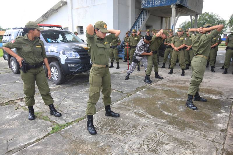 “A sociedade está prestes a receber novos policiais, profissionais prontos e treinados para defender o cidadão. Mesmo ainda não tendo encerrado o curso, já me sinto um PM. A instituição pode ter certeza que estarei sempre de pronto-emprego para atender no que ela precisar de mim”. A fala do aluno do Centro de Formação, dita nesta segunda-feira (7) durante uma aula do Curso de Formação e Aperfeiçoamento de Praças (CFAP) da Polícia Militar do Pará, demonstra o sentimento dos cerca de 2 mil homens e mulheres que estão próximos de encerrar o curso e iniciar seus trabalhos nas ruas. Em Belém, na sede do CFAP, estão em fase de conclusão da formação, cerca de 500 alunos (foto), entre homens e mulheres. Já no interior do Estado, outros 1. 500 passam pelo curso que também acontece nos municípios Conceição do Araguaia, Itaituba, Santarém, Marabá, Parauapebas, Castanhal, Santa Izabel do Pará, Tucuruí, Paragominas, Capanema, Bragança, Altamira, Barcarena, Soure e Breves. A previsão é que no início de agosto deste ano, todos já estejam efetivamente nas ruas. Aprovados no último concurso público da instituição, os futuros policiais estão desde outubro de 2017 participando de um novo modelo formação. De acordo com o major Arthur Silva, sub-comandante do CFAP, a mudança na grade do curso quase dobrou o número de horas aula.
FOTO: RODOLFO OLIVEIRA / AG. PARÁ
DATA: 08.05.2018
BELÉM - PARÁ <div class='credito_fotos'>Foto: Rodolfo Oliveira/Ag. Pará | <a href='/midias/2018/originais/a1f754e2-c054-4a68-a3ac-a0c01790eee2.jpg' download><i class='fa-solid fa-download'></i> Download</a></div>