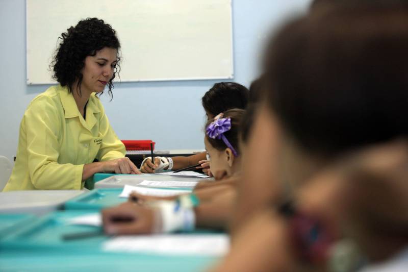 Na FHCGV, a pequena R.S. divide as aulas com mais cinco crianças, de 3 a 12 anos, internadas no hospital. A sala de aula, que fica em um dos ambientes hospitalares, acaba indo além das disciplinas escolares e se torna um local de acolhimento. “É muito gratificante oferecer a perspectiva para essas crianças de continuar as aulas mesmo em um ambiente hospitalar. A gente devolve um pouco do que é a vida lá fora. E aqui eles trazem tudo pra gente, o medo de fazer cirurgia, a saudade de casa... Às vezes tenho que mudar meu cronograma de aulas para ouvir os relatos das crianças e levar todo o apoio para elas”, destaca a professora Vanise Cavalcante, 37 anos (foto).
FOTO: SIDNEY OLIVEIRA / AG. PARÁ
DATA: 08.11.2018
BELÉM - PARÁ <div class='credito_fotos'>Foto: Sidney Oliveira/Ag. Pará | <a href='/midias/2018/originais/aed353a9-177a-43f5-b530-ffbb7bc3c759.jpg' download><i class='fa-solid fa-download'></i> Download</a></div>