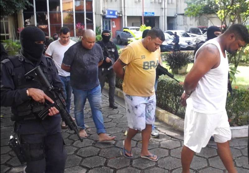 As Polícias Civil e Militar apresentaram, nesta terça-feira (29), em entrevista coletiva na Delegacia Geral, em Belém, informações sobre as prisões de oito pessoas (foto), entre elas dois policiais militares e um guarda municipal, por envolvimento na tentativa de furto mediante arrombamento de uma agência bancária, no município de Benevides. As prisões em flagrante foram realizadas por policiais militares, na madrugada de segunda-feira (28), por volta de 3 horas, em uma barreira policial, na rodovia BR-316, município de Marituba. Os presos foram conduzidos à Divisão de Repressão ao Crime Organizado (DRCO), onde foram autuados pelos crimes de associação criminosa, tentativa de furto qualificado, porte ilegal de arma de fogo e uso de documento falso. Com os presos, foram apreendidos materiais usados em arrombamentos e em corte de cofres e caixas eletrônicos, como cilindro de oxigênio, botijão de gás e mangueira usados em maçarico, além de ferramentas como furadeira e serra elétrica, colete balístico, luvas, máscara de oxigênio, entre outros equipamentos.
FOTO: ASCOM / POLÍCIA CIVIL
DATA: 29.05.2018
BELÉM - PARÁ <div class='credito_fotos'>Foto: Ascom / Polícia Civil | <a href='/midias/2018/originais/b1d31ad9-7258-4a10-9b32-a6fa37e2eb02.jpg' download><i class='fa-solid fa-download'></i> Download</a></div>