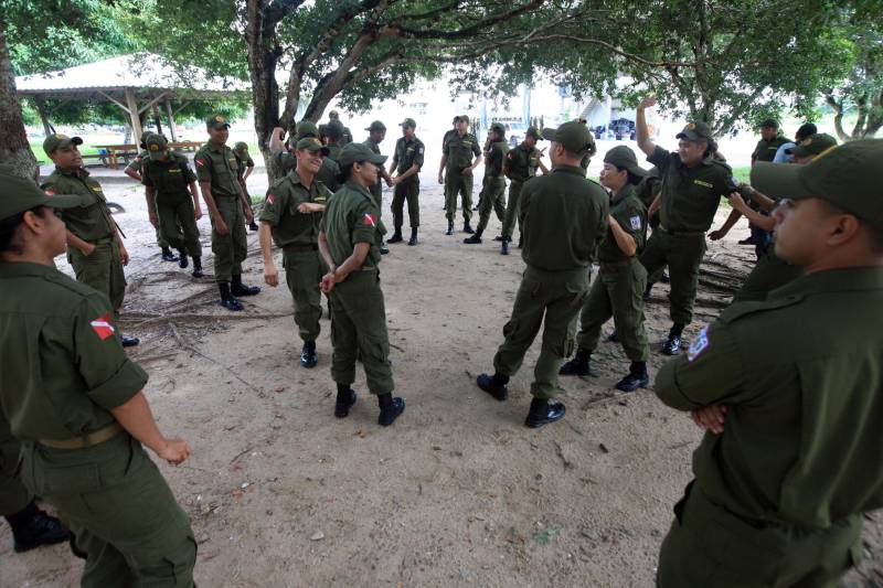 “A sociedade está prestes a receber novos policiais, profissionais prontos e treinados para defender o cidadão. Mesmo ainda não tendo encerrado o curso, já me sinto um PM. A instituição pode ter certeza que estarei sempre de pronto-emprego para atender no que ela precisar de mim”. A fala do aluno do Centro de Formação, dita nesta segunda-feira (7) durante uma aula do Curso de Formação e Aperfeiçoamento de Praças (CFAP) da Polícia Militar do Pará, demonstra o sentimento dos cerca de 2 mil homens e mulheres que estão próximos de encerrar o curso e iniciar seus trabalhos nas ruas. Em Belém, na sede do CFAP, estão em fase de conclusão da formação, cerca de 500 alunos (foto), entre homens e mulheres. Já no interior do Estado, outros 1. 500 passam pelo curso que também acontece nos municípios Conceição do Araguaia, Itaituba, Santarém, Marabá, Parauapebas, Castanhal, Santa Izabel do Pará, Tucuruí, Paragominas, Capanema, Bragança, Altamira, Barcarena, Soure e Breves. A previsão é que no início de agosto deste ano, todos já estejam efetivamente nas ruas. Aprovados no último concurso público da instituição, os futuros policiais estão desde outubro de 2017 participando de um novo modelo formação. De acordo com o major Arthur Silva, sub-comandante do CFAP, a mudança na grade do curso quase dobrou o número de horas aula.
FOTO: RODOLFO OLIVEIRA / AG. PARÁ
DATA: 08.05.2018
BELÉM - PARÁ <div class='credito_fotos'>Foto: Rodolfo Oliveira/Ag. Pará | <a href='/midias/2018/originais/b9603688-cf2e-4064-ad41-3cc84e013a6d.jpg' download><i class='fa-solid fa-download'></i> Download</a></div>