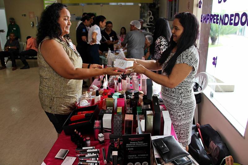 A movimentação diferente e os produtos à venda chamaram a atenção da técnica de enfermagem do Hospital Público Estadual Galileu, Alba Oliveira. “Olhei todas as mesas, parei para ouvir as histórias e descobri que existe algo além do empreendedorismo, que é a coragem dessas mulheres”, conta a colaboradora. As histórias que chamaram a atenção de Alba são de mulheres que fazem parte do Canto da Empreendedora, projeto do Hospital Oncológico Infantil Octávio Lobo que estimula o empreendedorismo e a autonomia financeira das mães e acompanhantes das crianças e adolescentes em tratamento na unidade. Com uma feira realizada por mês, o Canto da Empreendedora chegou a sua nona edição na terça-feira (8) e a ação no Hospital Galileu foi a primeira fora do Oncológico Infantil. Na foto, a vendedora de cosméticos, Vilma de Oliveira (d).
FOTO: ASCOM / HOIOL
DATA: 09.05.2018
BELÉM - PARÁ <div class='credito_fotos'>Foto: ASCOM HOIOL | <a href='/midias/2018/originais/bc07db9d-bc99-464e-8a9e-09f4b7ea9c48.jpg' download><i class='fa-solid fa-download'></i> Download</a></div>