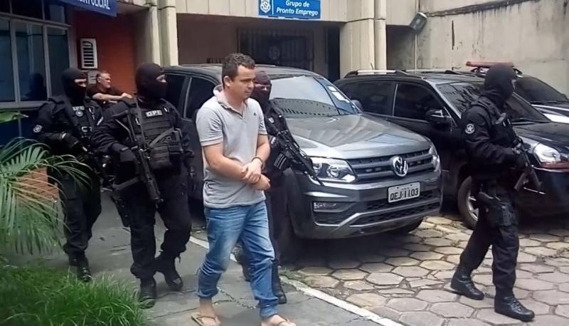 A Polícias Civil e Militar apresentaram, nesta segunda-feira (23), em entrevista coletiva, na Delegacia-Geral, em Belém, informações sobre a operação integrada que resultou na prisão do maranhense Adriano da Silva Brandão (foto), conhecido como "Adriano Pânico" ou "General", considerado um dos maiores assaltantes de carros-fortes em atuação no Brasil e líder de um grupo especializado nesse tipo de modalidade criminosa. Com ele, os policiais apreenderam um fuzil AK 47 - arma de guerra -, dezenas de munições; dois coletes à prova de balas; quatro capuzes tipo "balaclava"; luvas; cordel detonador de explosivos; carregadores de armas e roupas camufladas. O material é usado em ataques a veículos de empresas de transporte de valores. Adriano é um dos envolvidos no ataque a dois carros-fortes da empresa Prosegur em 30 de novembro do ano passado, perto da fazenda Cedro, a 50 quilômetros da sede de Marabá, sudeste do Estado. Com a prisão de Adriano, três envolvidos no assalto estão presos, um morreu e outros três estão foragidos. Na ocasião, os veículos faziam o transporte de numerários para agências bancárias na região, quando a estrada foi bloqueada por um bando armado de cerca de oito homens em três carros.
FOTO: ASCOM / POLÍCIA CIVIL
DATA: 23.04.2018
BELÉM - PARÁ <div class='credito_fotos'>Foto: Ascom / Polícia Civil | <a href='/midias/2018/originais/c6b4dd8b-97c1-4494-b838-625058ec0aae.jpg' download><i class='fa-solid fa-download'></i> Download</a></div>