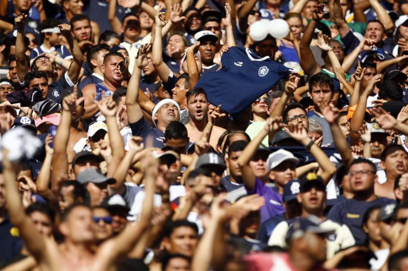 Foram exatos dois meses tentando assistir ao seu primeiro Re x Pa em 2018. Neste domingo, finalmente, a estudante Hendrea Souza convenceu o noivo, Arthur Pantoja, a levá-la ao Estádio Olímpico do Pará, o Mangueirão. E logo numa final. "Só trouxe porque vim no domingo passado e vi algumas mudanças no esquema de segurança", disse Arthur. "Tem mais policiais e a bebedeira em volta do estádio praticamente acabou", afirmou. As mudanças realmente aconteceram a partir do clássico do último dia primeiro e já surtiram efeito. A chamada “Operação Mangueirão” pôs em prática ações de ordenamento no entorno do estádio, com início a partir das 7h30 e encerramento às 20h. A operação determina a delimitação de espaço para atuação de vendedores ambulantes, proibição de veículos com sons automotivos ao redor do estádio e de barracas irregulares, seis pontos de bloqueio e dois para o ingresso de comerciantes e orientações ao público.
FOTO: THIAGO GOMES / AG. PARÁ
DATA: 08.04.2018
BELÉM - PARÁ <div class='credito_fotos'>Foto: Thiago Gomes /Ag. Pará | <a href='/midias/2018/originais/c72213e3-cd3d-4ef3-83d8-25948ce89dcd.jpg' download><i class='fa-solid fa-download'></i> Download</a></div>