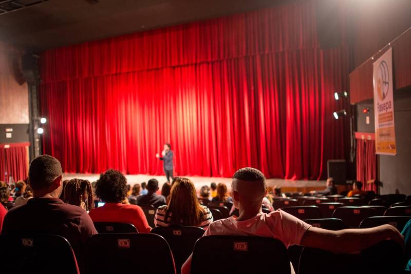 João*, de 17 anos, é natural de Bragança, nordeste do Pará. Há sete meses cumpre medida socioeducativa em uma unidade de internação do Estado após cometer um ato infracional no município onde reside. Mas na manhã desta terça-feira (5), em Belém, pôde vivenciar uma experiência inédita: participou de um espetáculo de teatro (foto) diante de dezenas de pessoas que se reuniram no Teatro Margarida Schivasappa, ao lado de outros 30 adolescentes e jovens privados de liberdade. Uma iniciativa pioneira no país que busca promover a ressocialização por meio da arte, fruto das atividades e oficinas pedagógicas realizadas dentro de espaços gerenciados pela Fundação de Atendimento Socioeducativo do Pará (Fasepa). “Eu nunca tinha vindo em um teatro e isso ficará marcado em mim”, disse o socioeducando. Tímido, ele revelou a vontade de deixar para trás os erros cometidos e seguir um futuro completamente novo, com os primeiros passos sendo dados hoje. “Isso despertou algo dentro de mim, pensar na minha vida e em sair do mundo das drogas. Quem sabe me tornar um ator?” divagou.

FOTO: FERNANDO SETTE / ASCOM IOE
DATA: 05.06.2018
BELÉM - PARÁ <div class='credito_fotos'>Foto: FERNANDO SETTE CÂMARA / ASCOM IOE   |   <a href='/midias/2018/originais/c95d4377-426d-465d-9ffa-b9a2fa8201ed.jpg' download><i class='fa-solid fa-download'></i> Download</a></div>