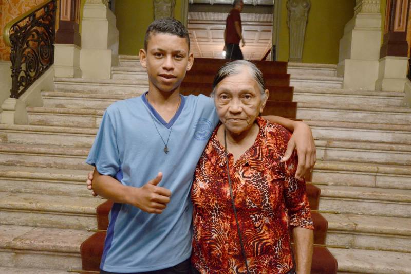 Durante cerca de uma hora, na tarde desta sexta-feira, 23, mais de quinhentos estudantes da rede pública estadual tiveram a oportunidade de conhecer um pouco mais sobre o universo da ópera, tendo como palco um dos mais importantes monumentos da capital paraense: o Theatro da Paz. Estamos falando do projeto “Concertos Didáticos”, uma iniciativa do Conservatório Carlos Gomes, em parceria com as Secretarias de Estado de Educação (Seduc) e Municipal de Belém (Semec). Na foto, a aposentada Raimunda Reis (d), de 73 anos, também nunca tinha ido ao Theatro da Paz. Ela decidiu acompanhar o neto Madson Barbosa (e), de 15 anos, matriculado no quinto ano do Ensino Fundamental da escola Ester Bandeira. “Estou encantada, nunca tinha visto algo tão lindo assim. As peças que eles apresentaram são maravilhosas, coisa de outro mundo”.
FOTO: RAI PONTES / ASCOM SEDUC
DATA: 23.03.2018
BELÉM - PARÁ <div class='credito_fotos'>Foto: Rai Pontes/Ascom Seduc | <a href='/midias/2018/originais/cd8aca2f-d9d9-482b-b4f1-6da22aa1f88d.jpg' download><i class='fa-solid fa-download'></i> Download</a></div>