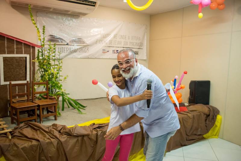 “A cultura tem o poder de emocionar”. A frase dita pela professora Ruth Valin marcou o tom do Sarau Literário na manhã desta sexta-feira, 8, no Preventório Santa Terezinha, no bairro do Marco, em Belém, que contou com a presença do escritor paraense Daniel Leite (com barba), homenageado pelas crianças atendidas pela instituição e os alunos da Escola Estadual Santa Terezinha, que funciona no mesmo prédio. Elas cantaram músicas infantis e recitaram trechos das obras “A história das crianças que plantaram um rio” e “A menina árvore”, de Daniel Leite, além de apresentar uma dramatização sobre a primeira obra. Muito concentrados e com a leitura bem ensaiada, os pequeninos emocionaram a todos, principalmente o escritor convidado para o sarau. Segundo a professora Odinéia Bastos, que orientou os alunos na leitura do livro “A história das crianças que plantaram um rio”, elas soltaram a imaginação durante a leitura da obra, e dessa viagem saíram desenhos, pinturas, colagens e poemas, que enfeitaram o auditório e os corredores da instituição, encantando a todos os presentes.
FOTO: FERNANDO SETTE CÂMARA / ASCOM IOE
DATA: 08.06.2018
BELÉM - PARÁ <div class='credito_fotos'>Foto: FERNANDO SETTE CÂMARA / ASCOM IOE | <a href='/midias/2018/originais/cf5b827c-dcba-43cd-9f5d-48782d66cb62.jpg' download><i class='fa-solid fa-download'></i> Download</a></div>
