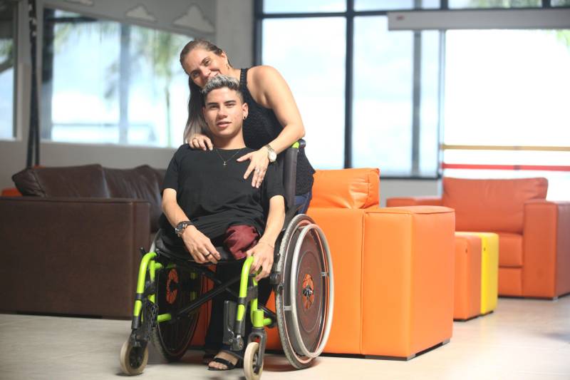 A cadeira de rodas que acompanha Luis Gustavo (primeiro plano) desde pequeno em nada atrapalha a vida do jovem com 17 anos. Ele faz o convênio, cursa inglês e treina bocha adaptada há quatro anos. Em 2017, foi campeão nacional paralímpico escolar representando o Estado do Pará na competição. Luis nasceu com artogripose e teve os dois fêmures fraturados durante o parto, segundo a mãe dele, Geisy Aleixo (segundo plano), de 40 anos. Juntos, eles estiveram na última semana conhecendo o Centro Integrado de Inclusão e Reabilitação (CIIR), que será inaugurado no próximo dia 12 de abril pelo Governo do Estado. o CIIR vai funcionar um Centro Especializado em Reabilitação (CER IV) para usuários com deficiência auditiva, física, intelectual e visual; uma oficina ortopédica e um Centro de Especialidades Odontológicas (CEO II). A obra, orçada em mais de R$ 32 milhões com recursos do tesouro estadual,faz parte das ações Governo do Estado para ampliar os serviços já oferecidos pela Secretaria de Estado de Saúde (Sespa). O Centro será administrado em parceria com o Instituto Nacional de Desenvolvimento Social e Humano (INDSH).
FOTO: MARCELO LELIS / AG. PARÁ
DATA: 06.04.2018
BELÉM - PARÁ <div class='credito_fotos'>Foto: Marcelo Lelis / Ag. Pará | <a href='/midias/2018/originais/d226f75f-c2f4-43f7-aee0-ca7603286d41.jpg' download><i class='fa-solid fa-download'></i> Download</a></div>