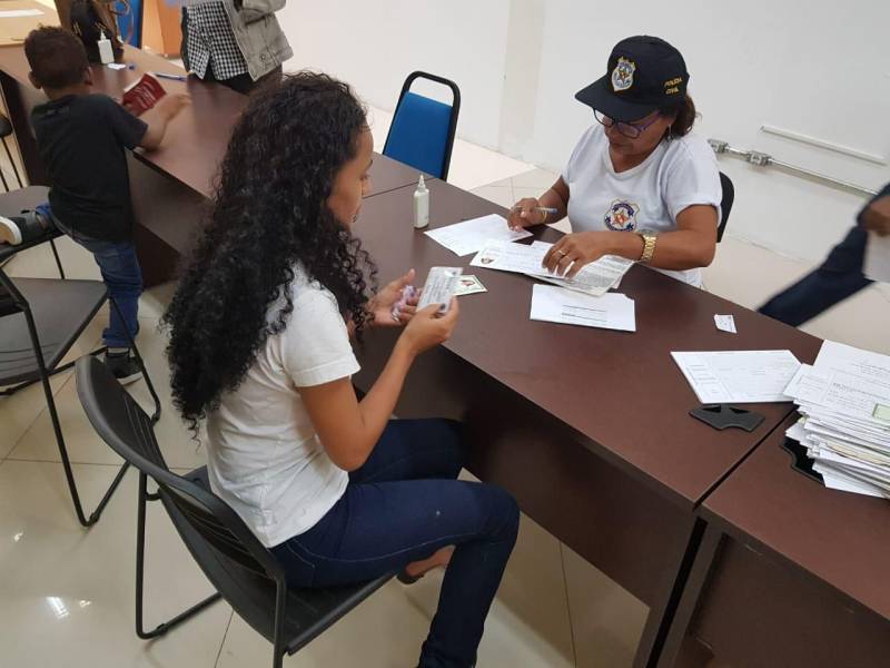 Diante da grande procura por emissão de carteira de identidade na Estação Cidadania Marabá, no sudeste paraense, a fila de espera para tirar o Registro Geral (RG) já previa atendimento até 2019. Para reduzir esse tempo de espera, a Polícia Civil do Pará começou nesta sexta-feira (23) a “Operação Polícia Cidadã”, no segundo piso do Shopping Center da sede municipal. O mutirão, que conta com 11 servidores da Secretaria de Estado de Segurança Pública e Defesa Social (Segup), prevê a emissão de 300 documentos por dia. Na foto, Adrielle Maria de Santos Silva.
FOTO: KÉLIA SANTOS / ASCOM CRGSP
DATA: 23.03.2018
MARABÁ - PARÁ <div class='credito_fotos'>Foto: KÉLIA SANTOS / ASCOM CRGSP | <a href='/midias/2018/originais/d30f2b81-0954-4c11-a9dd-f1b31d9e9806.jpg' download><i class='fa-solid fa-download'></i> Download</a></div>
