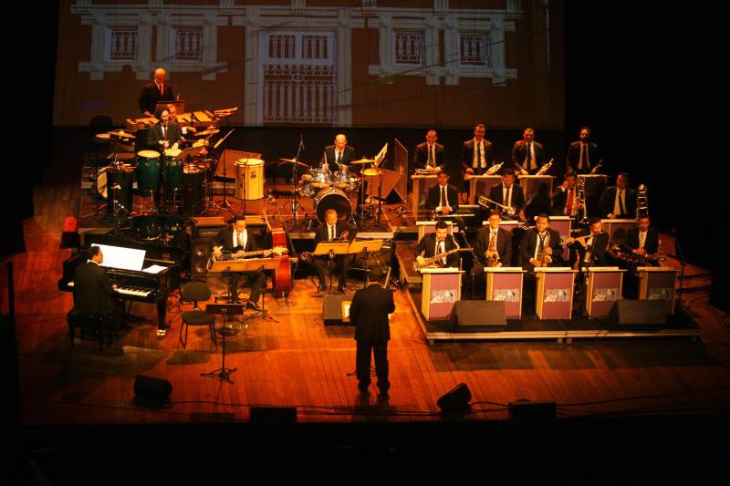 Os sons tradicionais de ritmos da Amazônia se misturaram com arranjos jazzísticos na noite de quinta-feira (15), no concerto “Celebrando o Theatro da Paz e Waldemar Henrique”, realizado pela Amazônia Jazz Band para comemorar os 140 anos do teatro e os 113 anos do maestro paraense, um dos mais importantes do país. Com a regência do maestro Nelson Neves, a noite teve uma convidada especial que encantou a plateia com seu tom de voz, a cantora Simone Almeida. O evento foi uma realização do Governo do Estado do Pará, por meio da Secretaria de Estado de Cultura (Secult) e da Academia Paraense de Música (APM). Para começar o espetáculo, “Foi Boto, Sinhá”, composição de Waldeco - como é carinhosamente chamado o regente e compositor - com arranjo de Tynnoko Costa, já arrebatou o público: sons de pássaros, barulhos de folhagens em movimento, de água. Um pouco da floresta era possível ouvir, de forma instrumental, em excelente execução dos músicos da big band. Logo depois, uma composição norte-americana deu o tom da noite de gala. Com sonoridade marcante, “The Phat Pack”, de Gordon Goodwin, mostrou como o jazz clássico pode combinar com a sonoridade da nossa região.

FOTO: CARLOS SODRÉ / AG PARÁ
DATA: 16.02.2018
BELÉM - PARÁ <div class='credito_fotos'>Foto: CARLOS SODRÉ / AG. PARÁ    |   <a href='/midias/2018/originais/d6cfb9fb-6d3a-4242-9ae2-827f4e19596d.jpg' download><i class='fa-solid fa-download'></i> Download</a></div>