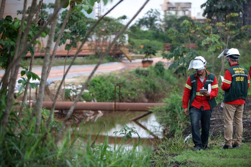 A Secretaria de Estado de Meio Ambiente e Sustentabilidade (Semas) notificou oficialmente a Hydro, na tarde desta terça-feira (27), por conta do não cumprimento do prazo de 48 horas dado pelo governo para que a empresa reduzisse os níveis das bacias de resíduos ao nível de, pelo menos, um metro, conforme determina a legislação ambiental. A notificação foi entregue por técnicos da Semas na sede da refinaria, em Barcarena, a 112 quilômetros de Belém. A determinação é que a produção de alumina seja reduzida pela metade. A Semas também triplicará a multa definida anteriormente, cumprindo a legislação ambiental em vigor, para R$ 1 milhão por dia de descumprimento (ou 300 mil Unidades de Padrão Fiscal). A empresa informou formalmente que reduziu os índices, mas não integralmente no total determinado de um metro. Técnicos das diretorias de Fiscalização e Licenciamento Ambiental da Semas acompanham diariamente o volume de água das bacias, tanto dos depósitos de rejeitos sólidos da indústria quanto do sistema de tratamento de água.
FOTO: THIAGO GOMES / AG PARÁ
DATA: 27.02.2018
BARCARENA - PARÁ <div class='credito_fotos'>Foto: Thiago Gomes /Ag. Pará | <a href='/midias/2018/originais/d7da8606-5cd2-4cd7-a083-3472eb1c8477.jpg' download><i class='fa-solid fa-download'></i> Download</a></div>