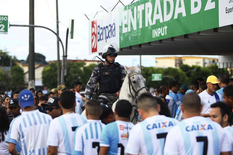 Foram exatos dois meses tentando assistir ao seu primeiro Re x Pa em 2018. Neste domingo, finalmente, a estudante Hendrea Souza convenceu o noivo, Arthur Pantoja, a levá-la ao Estádio Olímpico do Pará, o Mangueirão. E logo numa final. "Só trouxe porque vim no domingo passado e vi algumas mudanças no esquema de segurança", disse Arthur. "Tem mais policiais e a bebedeira em volta do estádio praticamente acabou", afirmou. As mudanças realmente aconteceram a partir do clássico do último dia primeiro e já surtiram efeito. A chamada “Operação Mangueirão” pôs em prática ações de ordenamento no entorno do estádio, com início a partir das 7h30 e encerramento às 20h. A operação determina a delimitação de espaço para atuação de vendedores ambulantes, proibição de veículos com sons automotivos ao redor do estádio e de barracas irregulares, seis pontos de bloqueio e dois para o ingresso de comerciantes e orientações ao público.
FOTO: THIAGO GOMES / AG. PARÁ
DATA: 08.04.2018
BELÉM - PARÁ <div class='credito_fotos'>Foto: Thiago Gomes /Ag. Pará | <a href='/midias/2018/originais/d7fa7c88-22ef-4a61-879a-111fade6d468.jpg' download><i class='fa-solid fa-download'></i> Download</a></div>