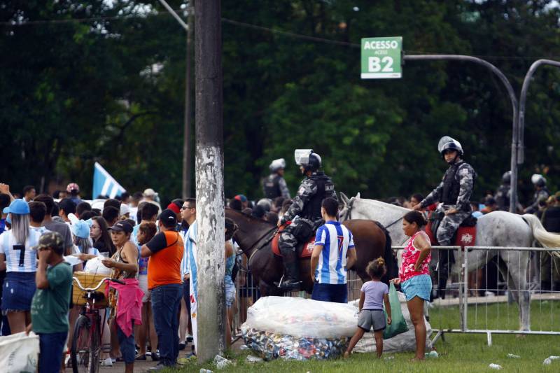Foram exatos dois meses tentando assistir ao seu primeiro Re x Pa em 2018. Neste domingo, finalmente, a estudante Hendrea Souza convenceu o noivo, Arthur Pantoja, a levá-la ao Estádio Olímpico do Pará, o Mangueirão. E logo numa final. "Só trouxe porque vim no domingo passado e vi algumas mudanças no esquema de segurança", disse Arthur. "Tem mais policiais e a bebedeira em volta do estádio praticamente acabou", afirmou. As mudanças realmente aconteceram a partir do clássico do último dia primeiro e já surtiram efeito. A chamada “Operação Mangueirão” pôs em prática ações de ordenamento no entorno do estádio, com início a partir das 7h30 e encerramento às 20h. A operação determina a delimitação de espaço para atuação de vendedores ambulantes, proibição de veículos com sons automotivos ao redor do estádio e de barracas irregulares, seis pontos de bloqueio e dois para o ingresso de comerciantes e orientações ao público.
FOTO: THIAGO GOMES / AG. PARÁ
DATA: 08.04.2018
BELÉM - PARÁ <div class='credito_fotos'>Foto: Thiago Gomes /Ag. Pará | <a href='/midias/2018/originais/e6fd76b5-3eae-44bf-805b-88290cbd58c5.jpg' download><i class='fa-solid fa-download'></i> Download</a></div>