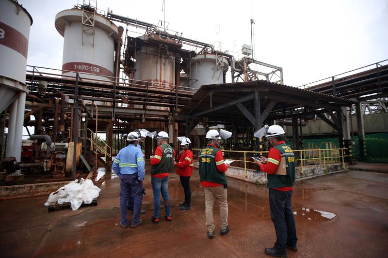 A Secretaria de Estado de Meio Ambiente e Sustentabilidade (Semas) notificou oficialmente a Hydro, na tarde desta terça-feira (27), por conta do não cumprimento do prazo de 48 horas dado pelo governo para que a empresa reduzisse os níveis das bacias de resíduos ao nível de, pelo menos, um metro, conforme determina a legislação ambiental. A notificação foi entregue por técnicos da Semas na sede da refinaria, em Barcarena, a 112 quilômetros de Belém. A determinação é que a produção de alumina seja reduzida pela metade. A Semas também triplicará a multa definida anteriormente, cumprindo a legislação ambiental em vigor, para R$ 1 milhão por dia de descumprimento (ou 300 mil Unidades de Padrão Fiscal). A empresa informou formalmente que reduziu os índices, mas não integralmente no total determinado de um metro. Técnicos das diretorias de Fiscalização e Licenciamento Ambiental da Semas acompanham diariamente o volume de água das bacias, tanto dos depósitos de rejeitos sólidos da indústria quanto do sistema de tratamento de água.
FOTO: THIAGO GOMES / AG PARÁ
DATA: 27.02.2018
BARCARENA - PARÁ <div class='credito_fotos'>Foto: Thiago Gomes /Ag. Pará | <a href='/midias/2018/originais/ea3e0ecd-0329-4393-9b4a-3410d3417a08.jpg' download><i class='fa-solid fa-download'></i> Download</a></div>