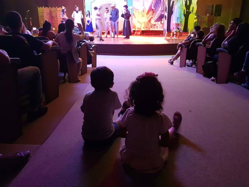 Uma plateia atenta e alegre aplaudiu os estudantes do 3º ano do Colégio Alvorada, em Marabá, que apresentaram a peça teatral adaptada de “O Auto da Compadecida” (foto), obra do escritor paraibano Ariano Suassuna, na programação do 1º Salão do Livro do Sul e Sudeste do Pará, que prossegue até o próximo dia 06 (domingo), no Carajás Centro de Convenções. Cláudia Borges, professora de Literatura, informou que a peça fez parte de uma semana literária da escola, voltada às leituras do Exame Nacional do Ensino Médio (Enem). “Foi um trabalho interdisciplinar com Português, Redação e Literatura. Nós buscamos valorizar o pensamento dos alunos, e cada um com sua personalidade deu corpo aos personagens. ‘Ariano Suassuna’ foi trabalhado porque é uma das obras que caem no Enem, e foi uma coisa gostosa de trabalhar porque estudamos o autor, o sotaque, expressões populares do Nordeste, vocabulário na Língua Portuguesa, o roteiro, o contexto histórico e a construção de cada personagem, respeitando o que o autor propôs para cada papel”, explicou.
FOTO: KÉLIA SANTOS / CRGSP
DATA: 02.05.2018
MARABÁ - PARÁ <div class='credito_fotos'>Foto: KÉLIA SANTOS / ASCOM CRGSP | <a href='/midias/2018/originais/ee5dbc59-60c2-4b52-be08-e70827a7b5b6.jpg' download><i class='fa-solid fa-download'></i> Download</a></div>