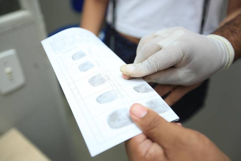 Uma média de 50 a 60 mil RGs foram emitidos (foto) por mês em todo o Pará pela Diretoria de Identificação "Enéas Martins" (Didem), da Polícia Civil, de janeiro a novembro de 2018. O número é considerado alto e é resultado da maior agilidade no atendimento para a emissão e entrega do documento, possível após a possibilidade de agendamento pelo site do órgão de segurança pública. Antes, longas filas se formavam na frente da Delegacia Geral do Estado, o principal posto de atendimento. A diretora da Didem, Juliete Monteiro, conta que com a modernização da polícia no interior do Estado contribuiu com o aumento das emissões e com a diminuição do prazo para a entrega do documento. “Tinha município que esperava até 40 dias. Com a informatização, o prazo diminuiu bastante”, diz. Além disso, Juliete lembra que o agendamento informatizado inibiu situações irregulares, como a venda de senha para o atendimento. Atualmente, 44 municípios do Estado são informatizados. Destes, 32 passaram pela modernização de sistema nos últimos oito anos de gestão do governador Simão Jatene. “Agora temos muito mais possibilidades no interior. Quem não tem posto de atendimento no seu município, pode fazer na cidade mais próxima. Temos muito ainda pela frente, mas estamos caminhando para que o usuário aguarde cada vez menos tempo para receber seu RG”, concluiu.

FOTO: MÁCIO FERREIRA / AG. PARÁ
DATA: 03.12.2018
BELÉM - PARÁ
 <div class='credito_fotos'>Foto: MÁCIO FERREIRA/ AG. PARÁ   |   <a href='/midias/2018/originais/ee6d8099-e402-45ba-acda-d77eefc11dd5.jpg' download><i class='fa-solid fa-download'></i> Download</a></div>