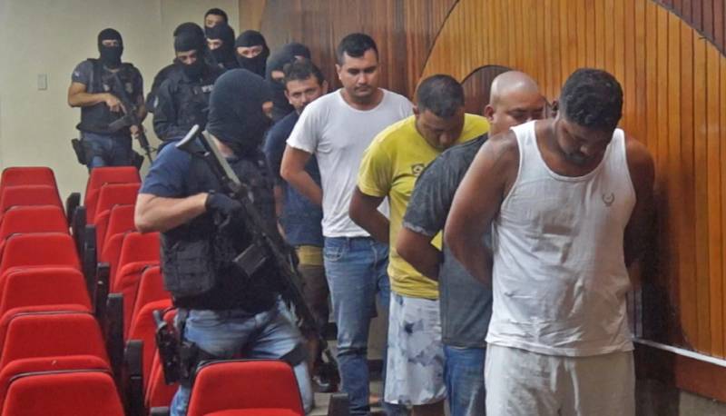 As Polícias Civil e Militar apresentaram, nesta terça-feira (29), em entrevista coletiva na Delegacia Geral, em Belém, informações sobre as prisões de oito pessoas (foto), entre elas dois policiais militares e um guarda municipal, por envolvimento na tentativa de furto mediante arrombamento de uma agência bancária, no município de Benevides. As prisões em flagrante foram realizadas por policiais militares, na madrugada de segunda-feira (28), por volta de 3 horas, em uma barreira policial, na rodovia BR-316, município de Marituba. Os presos foram conduzidos à Divisão de Repressão ao Crime Organizado (DRCO), onde foram autuados pelos crimes de associação criminosa, tentativa de furto qualificado, porte ilegal de arma de fogo e uso de documento falso. Com os presos, foram apreendidos materiais usados em arrombamentos e em corte de cofres e caixas eletrônicos, como cilindro de oxigênio, botijão de gás e mangueira usados em maçarico, além de ferramentas como furadeira e serra elétrica, colete balístico, luvas, máscara de oxigênio, entre outros equipamentos.
FOTO: ASCOM / POLÍCIA CIVIL
DATA: 29.05.2018
BELÉM - PARÁ <div class='credito_fotos'>Foto: Ascom / Polícia Civil | <a href='/midias/2018/originais/f8d4ec25-11a9-4222-9f46-20532caf198a.jpg' download><i class='fa-solid fa-download'></i> Download</a></div>