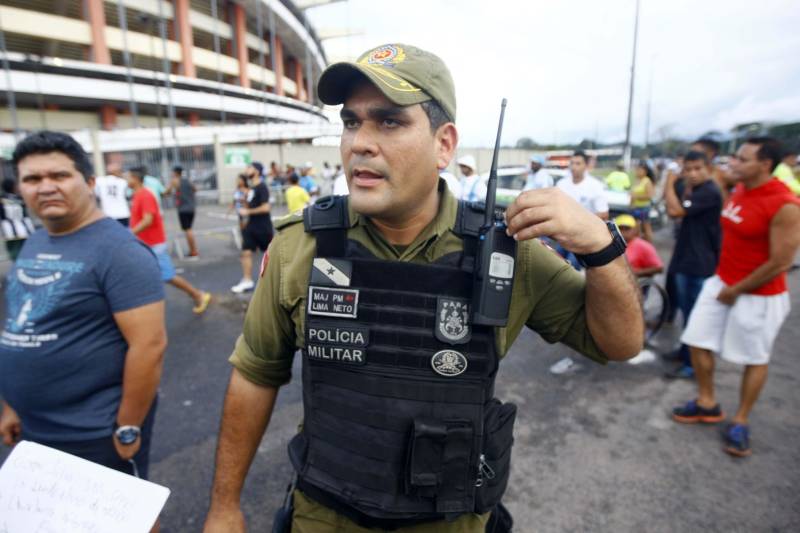 Foram exatos dois meses tentando assistir ao seu primeiro Re x Pa em 2018. Neste domingo, finalmente, a estudante Hendrea Souza convenceu o noivo, Arthur Pantoja, a levá-la ao Estádio Olímpico do Pará, o Mangueirão. E logo numa final. "Só trouxe porque vim no domingo passado e vi algumas mudanças no esquema de segurança", disse Arthur. "Tem mais policiais e a bebedeira em volta do estádio praticamente acabou", afirmou. As mudanças realmente aconteceram a partir do clássico do último dia primeiro e já surtiram efeito. A chamada “Operação Mangueirão” pôs em prática ações de ordenamento no entorno do estádio, com início a partir das 7h30 e encerramento às 20h. A operação determina a delimitação de espaço para atuação de vendedores ambulantes, proibição de veículos com sons automotivos ao redor do estádio e de barracas irregulares, seis pontos de bloqueio e dois para o ingresso de comerciantes e orientações ao público. Na foto, o major Lima Neto, da Polícia Militar do Estado.
FOTO: THIAGO GOMES / AG. PARÁ
DATA: 08.04.2018
BELÉM - PARÁ <div class='credito_fotos'>Foto: Thiago Gomes /Ag. Pará | <a href='/midias/2018/originais/f950d1f6-3543-44b4-b4b9-ebfcfcaa3977.jpg' download><i class='fa-solid fa-download'></i> Download</a></div>