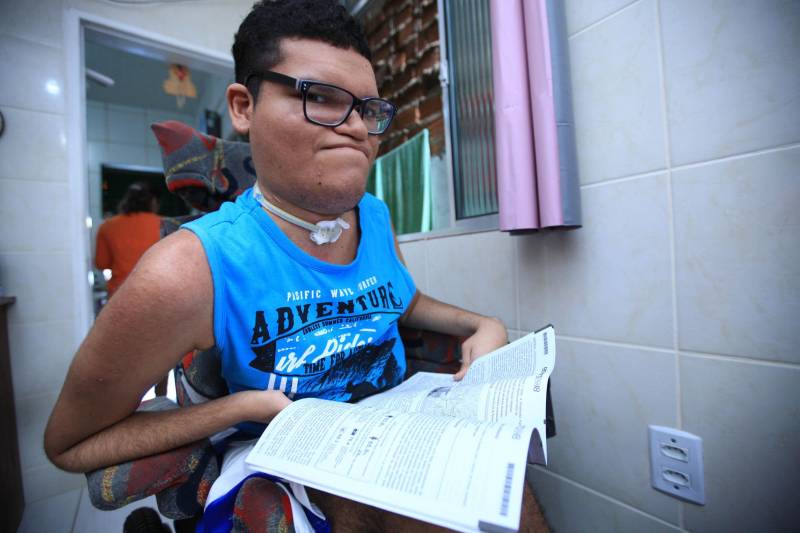 Junto com a Classe Hospitalar, existe também o projeto Atendimento Domiciliar que, hoje, atende 13 pacientes que se encontram em tratamento em casa. Um dos maiores orgulhos da equipe de educadores da Seduc é Breno Santiago, de 21 anos (foto). Aos dois anos, Breno teve uma infecção na medula e chegou a ser desenganado pelos médicos, mas resistiu e mesmo com comprometimentos na parte física e na fala, teve sua capacidade cognitiva preservada. Ele aprendeu a ler e a escrever com uma equipe de oito professores do Atendimento Domiciliar, e hoje se prepara para fazer a segunda prova do Exame Nacional de Ensino Médio (Enem), que acontece no próximo domingo (11).
FOTO: MÁCIO FERREIRA / AG. PARÁ
DATA: 08.11.2018
BELÉM - PARÁ <div class='credito_fotos'>Foto: MÁCIO FERREIRA/ AG. PARÁ | <a href='/midias/2018/originais/fed6918e-fc67-49b9-be50-4b276ccb06c6.jpg' download><i class='fa-solid fa-download'></i> Download</a></div>
