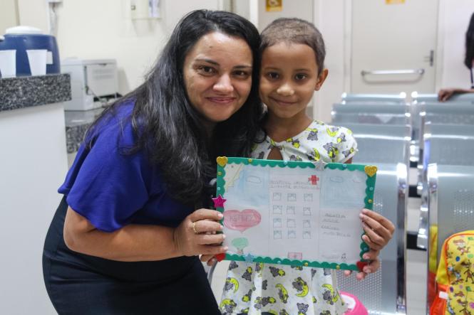 “Aqui tem amor, carinho e paixão”, com essas palavras e um desenho assinado com o nome em um coração, a pequena Ketley Rodrigues, de 7 anos, deixou uma homenagem aos profissionais do Hospital Oncológico Infantil Octávio Lobo, em Belém, após receber alta de uma internação de quase uma semana para continuidade do tratamento que faz contra um câncer no rim, descoberto há oito meses. 
NA FOTO:  Diretora do Hospital, Alba Muniz e  Ketley Rodrigues, de 7 anos
FOTO: DIVULGAÇÃO
DATA: 13.03.2019
BELÉM - PA <div class='credito_fotos'>Foto: Divulgação   |   <a href='/midias/2019/originais/137e3e27-3b23-4b9f-b02b-08757f306c92.jpg' download><i class='fa-solid fa-download'></i> Download</a></div>