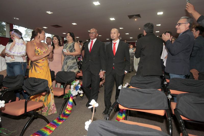 De vestido vermelho, a autónoma Kelly Ferrão, de 40 anos, segurando uma das mãos da noiva, a auxiliar de serviços gerais Suzana Pantoja, 35, não continha nos olhos a emoção pelo que estava por vir. "Chegamos aqui na luta, na raça mesmo. Estar aqui é um desafio vencido", confirmou, minutos antes de participar da 5a edição do Casamento Comunitário Homoafetivo, realizado na tarde desta sexta, 5, no auditório do Instituto de Ciências Jurídicas da Universidade Federal do Para (ICJ-UFPA). Além delas, outros dez casais de homens e mulheres gays, lésbicas, bissexuais e transexuais puderam oficializar, juridicamente, a relação estável, ou aos que queiram, apenas fazer a renovação dos votos. Embora não estivesse lotado, o espaço pareceu, diversas vezes, pequeno para comportar tanta emoção, orgulho e a certeza de que o amor sempre vence.
 <div class='credito_fotos'>Foto: Ricardo Amanajás / Ag. Pará   |   <a href='/midias/2019/originais/2851__j1o0911.jpg' download><i class='fa-solid fa-download'></i> Download</a></div>